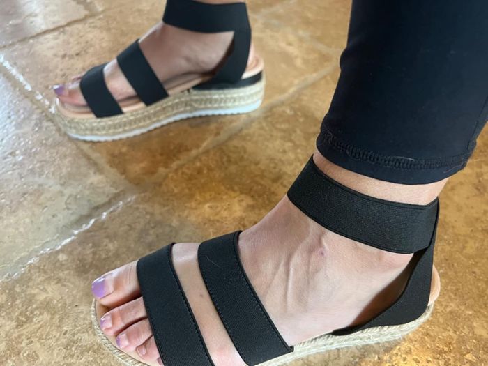 A reviewer in chic black espadrille wedge sandals