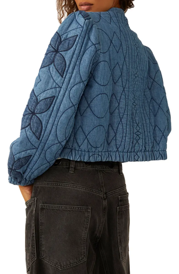 The back view reveals a quilted denim jacket featuring bold flower and geometric stitch patterns, teamed with dark high-waisted jeans.