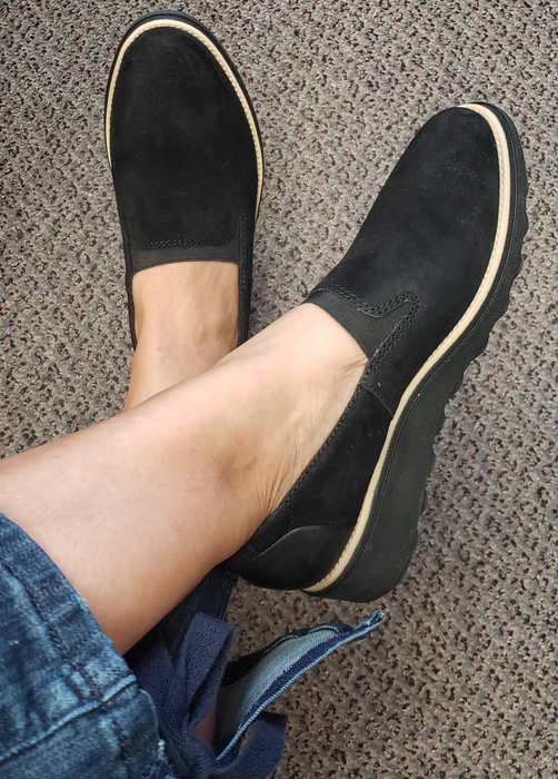 A reviewer wearing black loafers