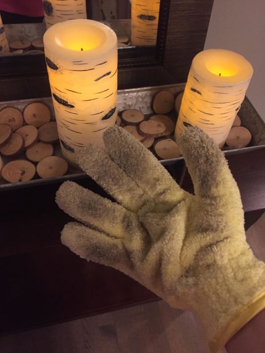 The reviewer shows the glove covered in dust after a thorough cleaning session.