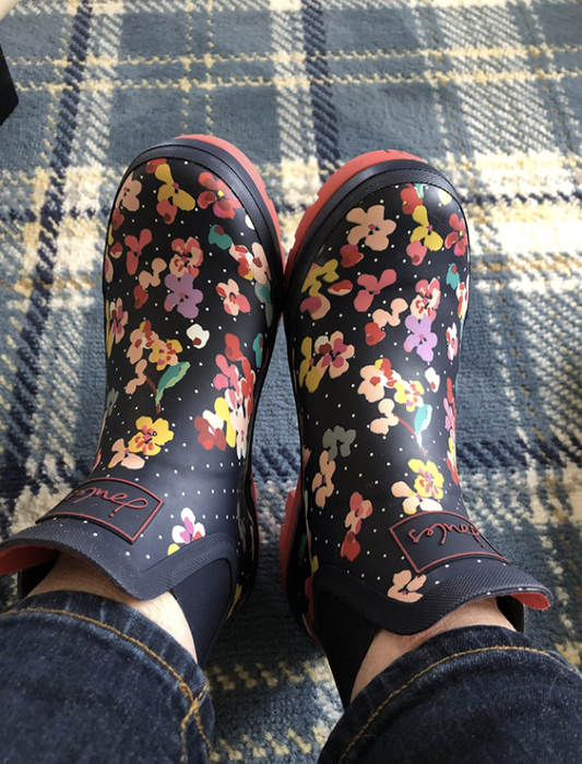 reviewer wearing ankle boots with a floral pattern