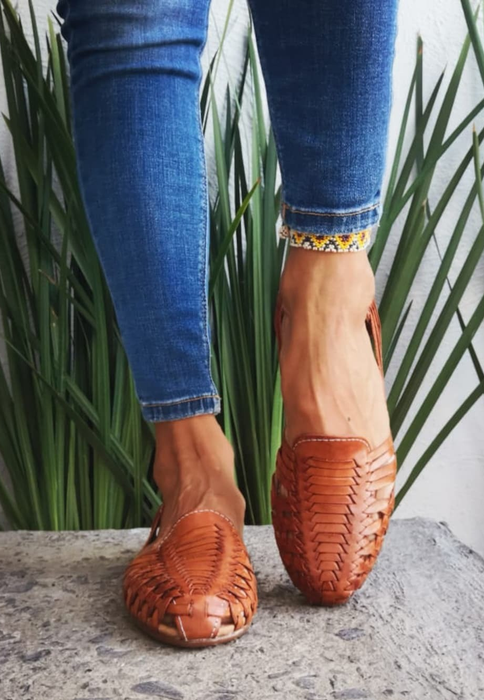 model wearing brown huaraches paired with jeans