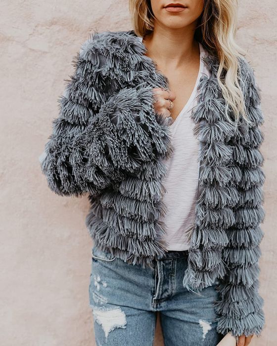 Close-up of model rocking the gray shaggy parka over a white tee and distressed jeans for a laid-back yet stylish look