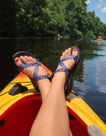 Reviewer sporting purple Chaco sandals while kayaking
