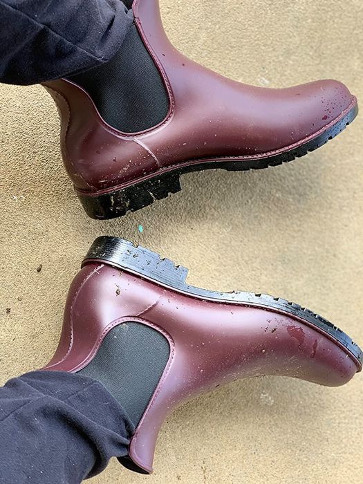 Reviewer wearing maroon boots with water droplets on them