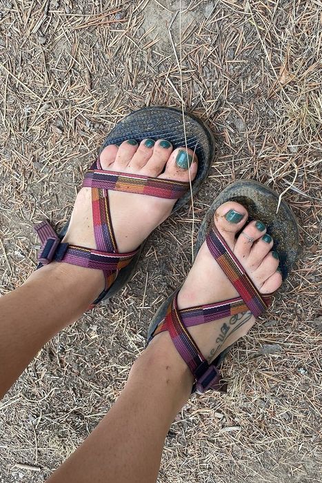 A reviewer wearing plaid strappy sandals.
