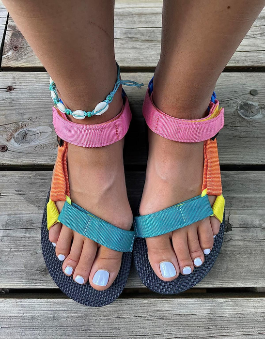 Reviewer's feet in colorful Teva sandals