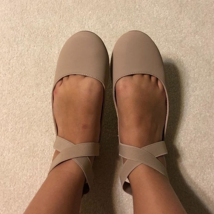 A reviewer photo featuring a pair of beige suede flats.