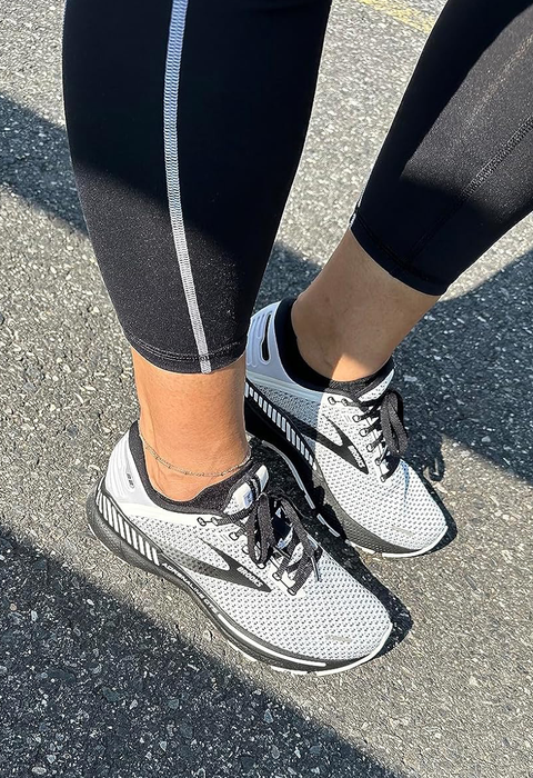 Reviewer sporting white and black running shoes