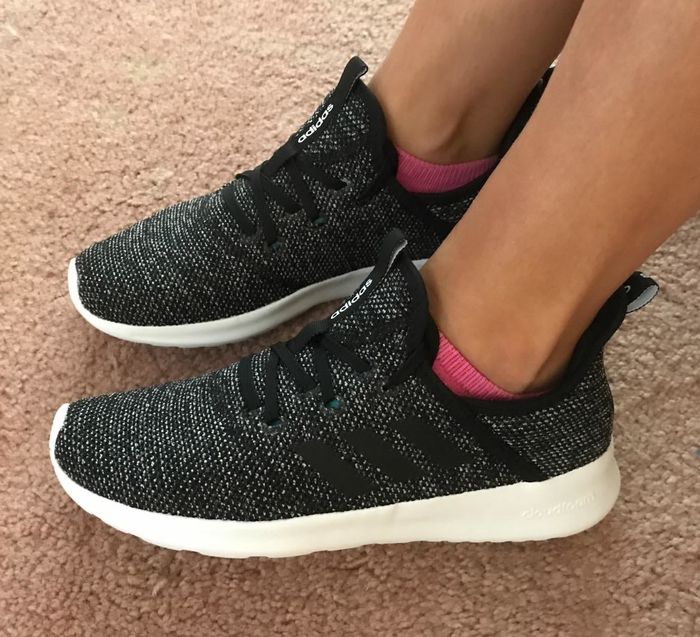 Another reviewer sporting black Adidas shoes with black laces, worn indoors.