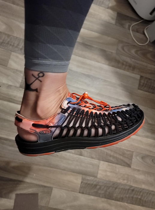 A person wearing navy blue woven cord shoes with printed details