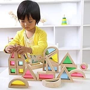 A child assembling shapes with rainbow-colored blocks