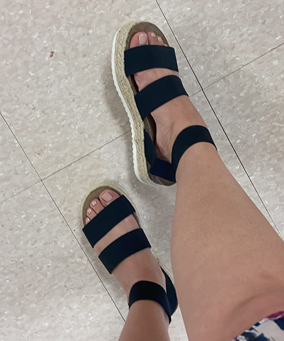 A reviewer wearing black platform espadrille sandals