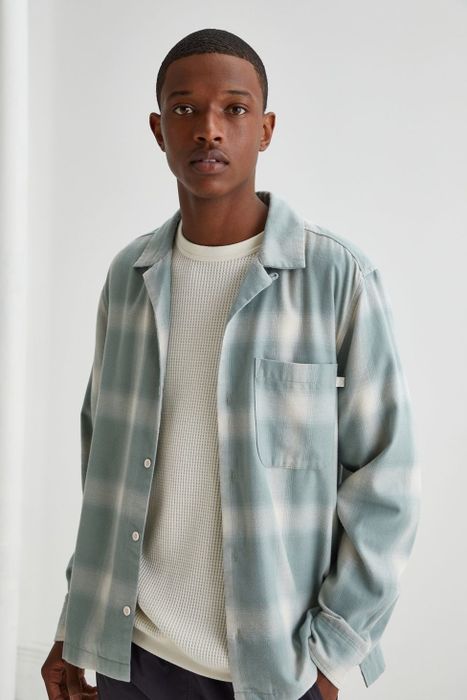 Model wearing a light blue and white plaid shirt with an all-over checkered design