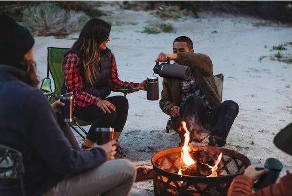 Models enjoying the convenience of the growler while camping at a scenic campsite.