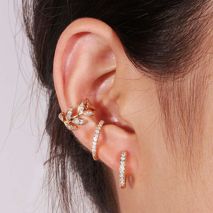 A model wearing gold earring cuffs on their ear