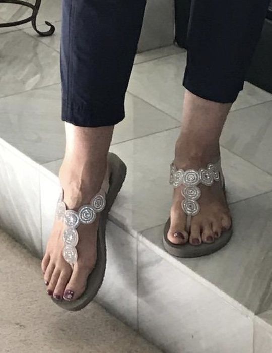 A reviewer lounging indoors while wearing the sandals.