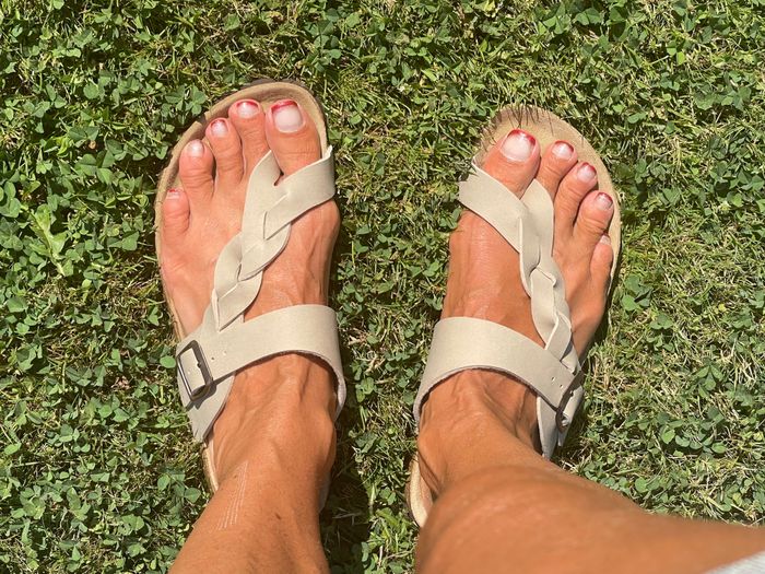 A reviewer rocking the sandals in a beige hue for a relaxed vibe
