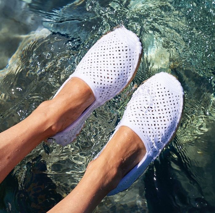 Reviewer wearing white espadrilles while standing in the water