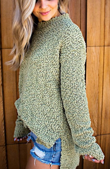 A model showcasing the fuzzy green sweater.