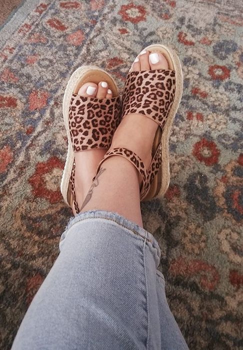 reviewer wearing the same espadrilles, now in a leopard print design