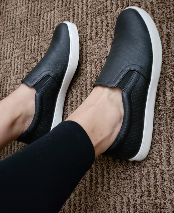 Reviewer wearing black slip-on shoes