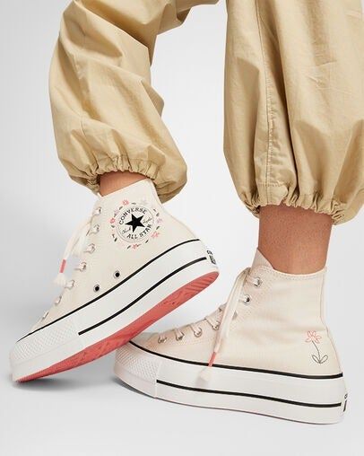 model rocking floral embroidered high-top Converse sneakers