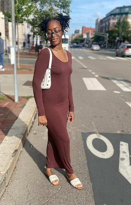 a reviewer dressed in a brown maxi dress and off-white slide sandals