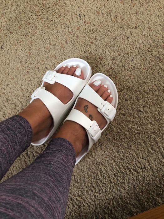 A reviewer wearing sandals in white.