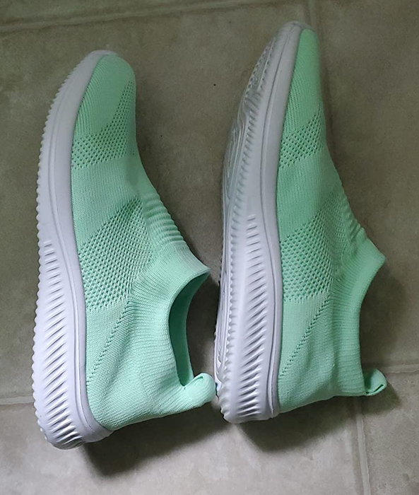 A reviewer shows off their light green slip-ons in a photo.