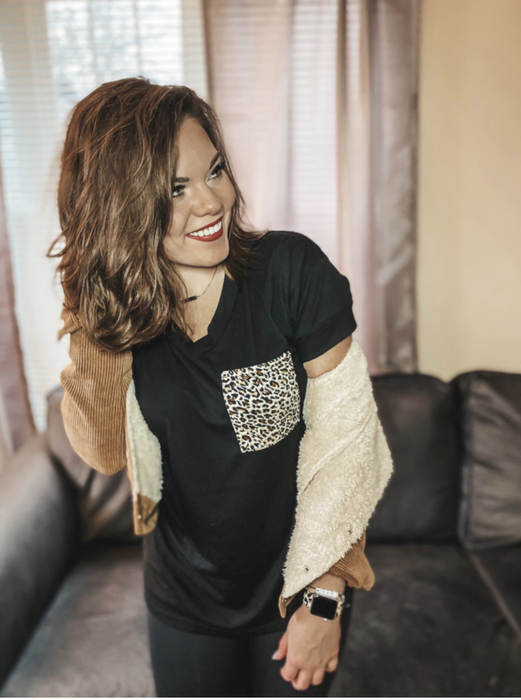 A reviewer's photo featuring a blank top with a leopard print pocket.