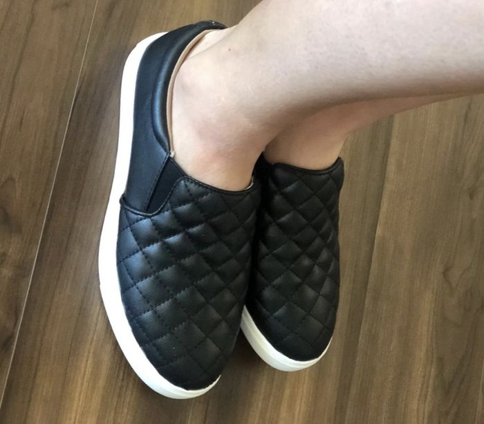 a reviewer wearing the black slip-on shoes