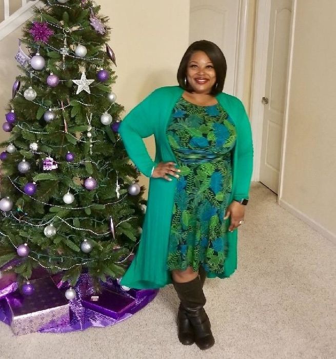 A reviewer wearing the long sweater in a light green shade