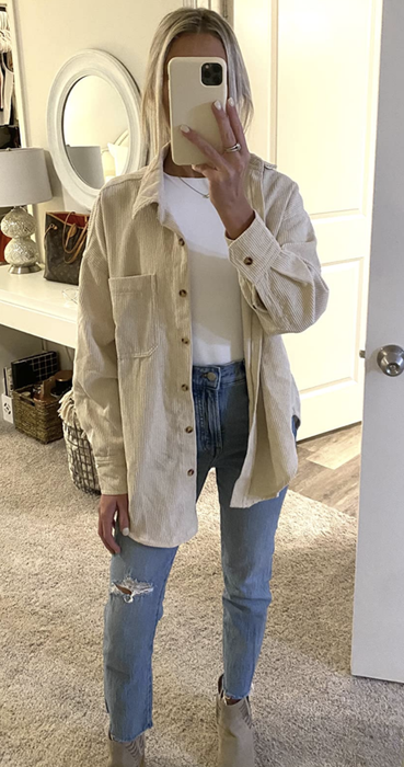 Reviewer snapping a mirror selfie in the cream-colored shirt