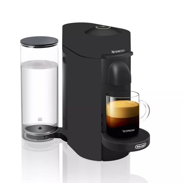A sleek black Nespresso coffee maker with a freshly brewed cup of coffee beside it.