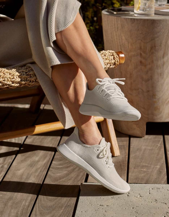 A model wearing white Allbirds sneakers