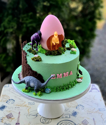 A dinosaur-themed birthday cake with a name