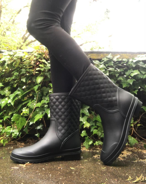 A reviewer wearing black waterproof boots.