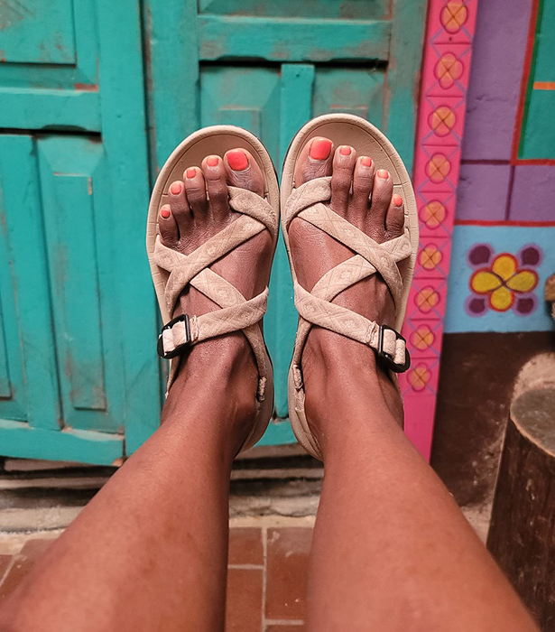 reviewer showcasing beige sandals with criss-cross straps