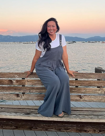 A reviewer sits comfortably, posing in grey-blue overalls.