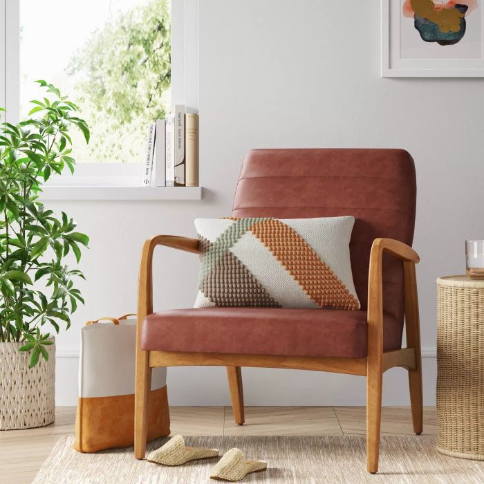 The brown chair with a wooden frame and arms, placed in a cozy living room setting.