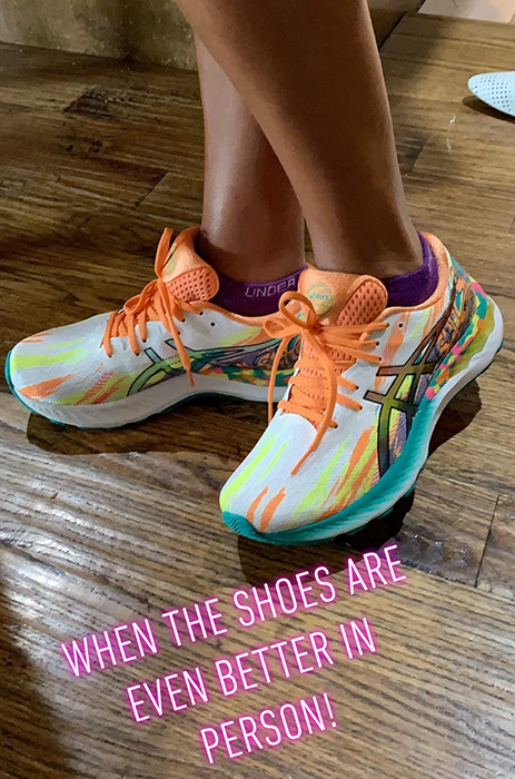 A reviewer sporting the shoes in vibrant orange and yellow.