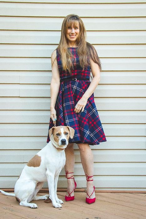 A reviewer is pictured wearing a dress in blue and red plaid patterns.