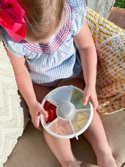Image of a child holding the round snack container