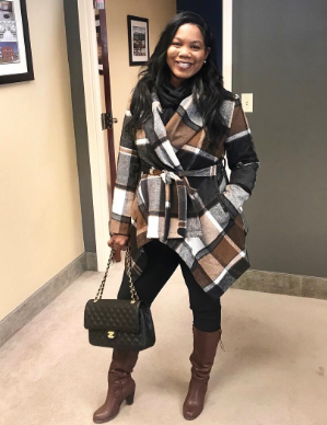 A reviewer wearing the coat in a brown and black checkered pattern