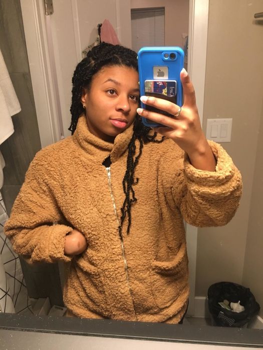 A reviewer wearing the zip-up coat in a cozy brown shade.