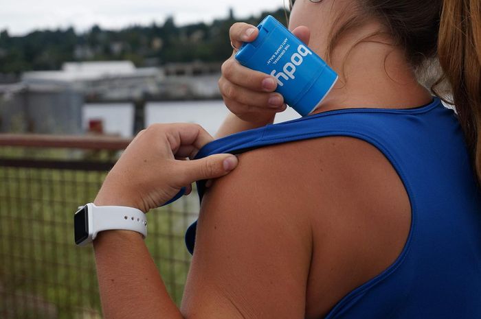 Model applying anti-chafing balm to prevent irritation