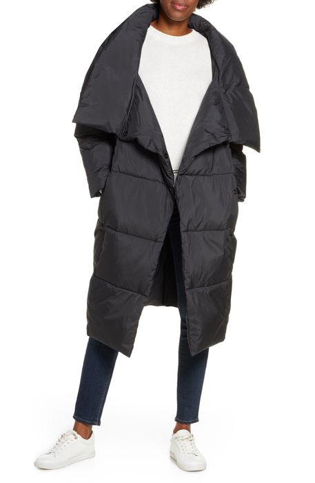 Model styling a long black puffer coat with a wide, open collar