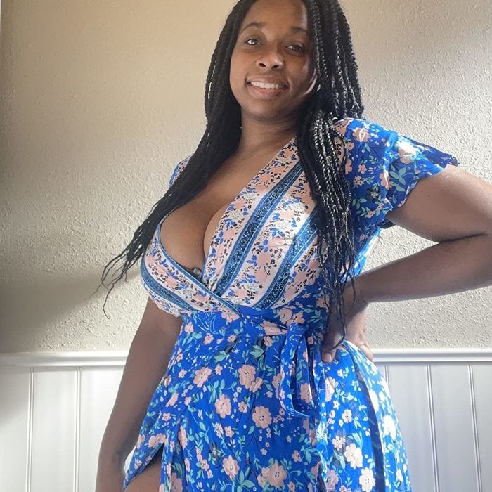 Reviewer is wearing the blue dress featuring pink floral patterns throughout.