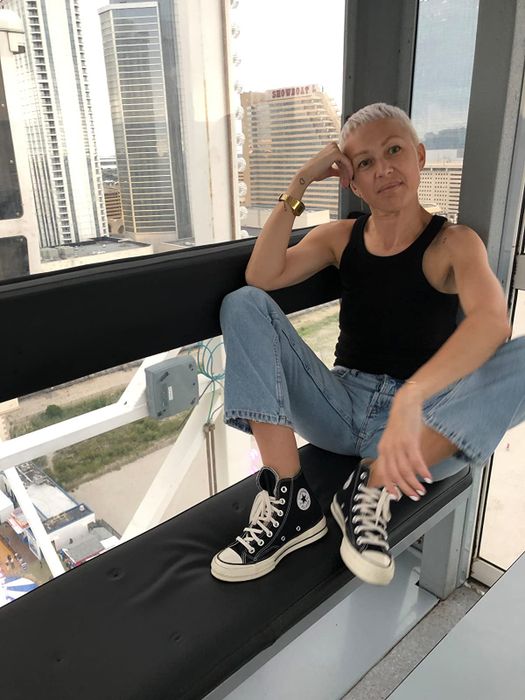 A reviewer wearing the black Converse sneakers.